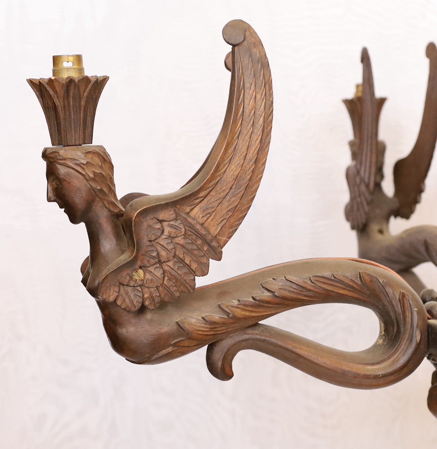 A Swiss Black Forest carved wood four light chandelier with caryatid branches and rose entwined stem, height 92cm. width 92cm